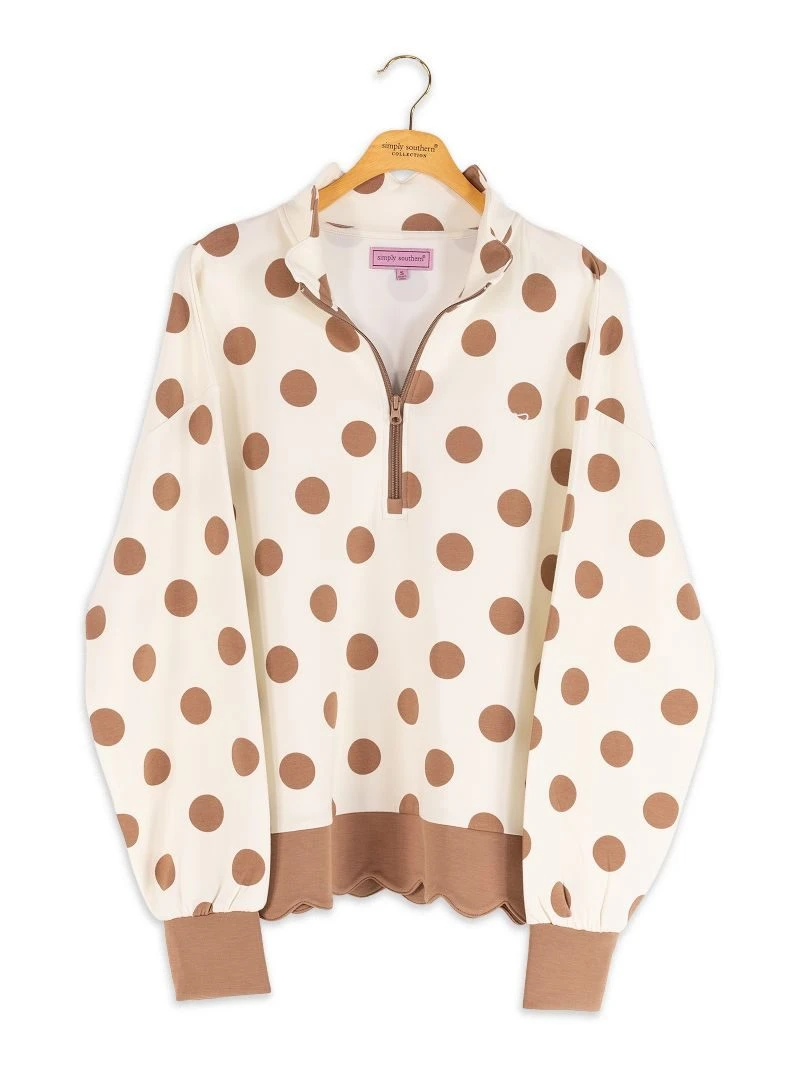 Polka dot sweater on a hanger with a visible brand label.