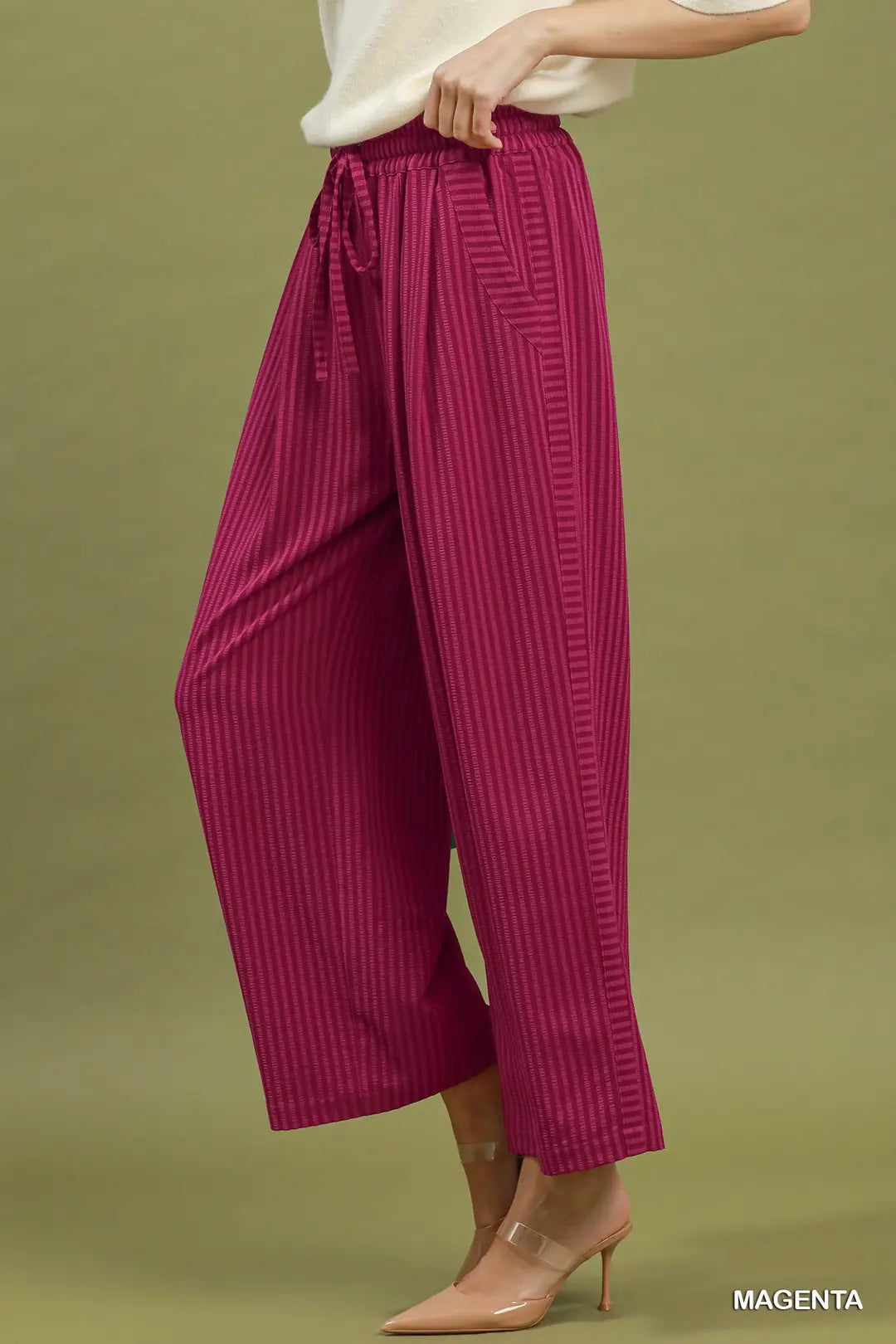 Magenta wide-leg pants worn by a person on a green background