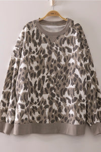 Leopard print sweatshirt on a hanger against a plain background