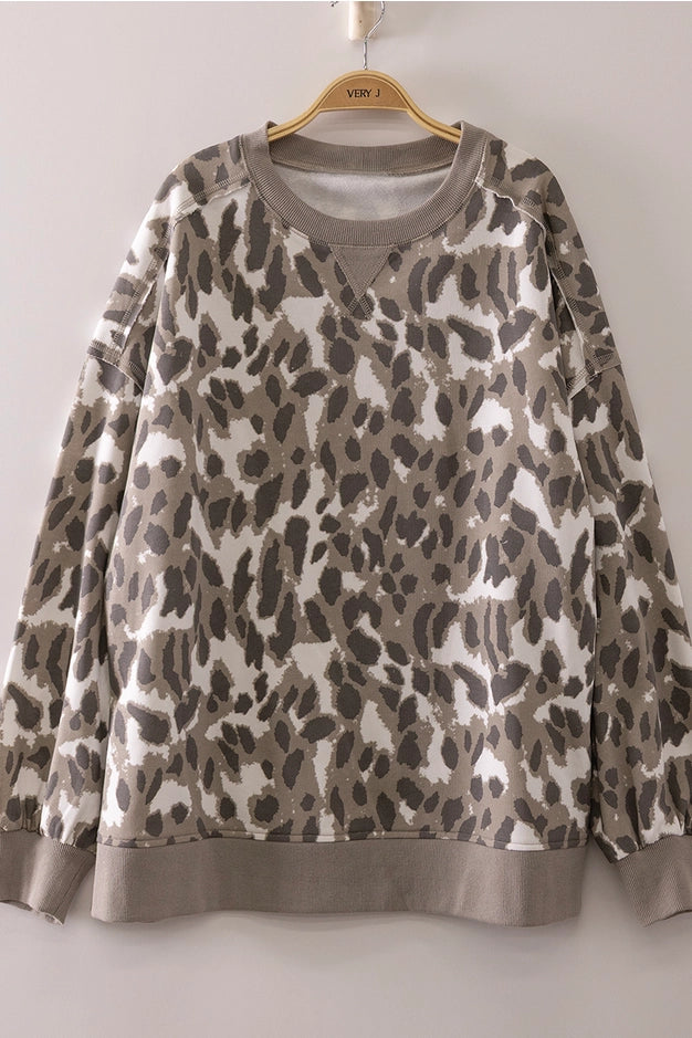 Leopard print sweatshirt on a hanger against a plain background