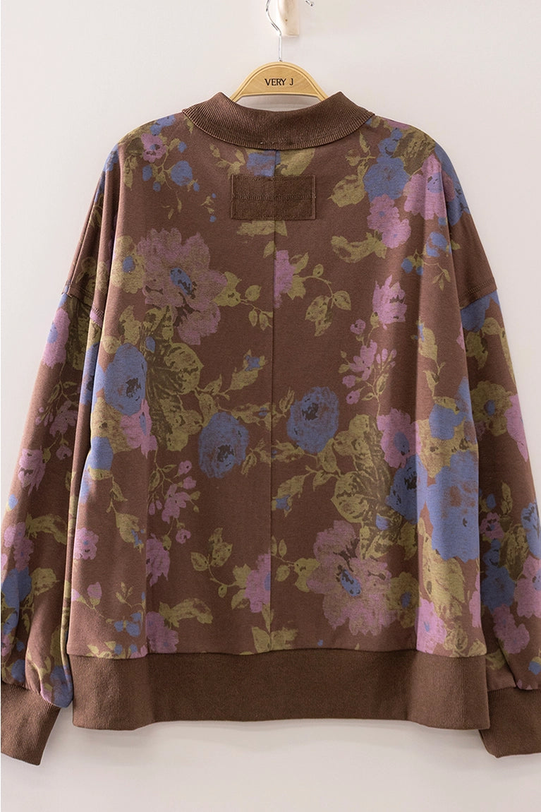 Floral patterned jacket on a hanger against a white background