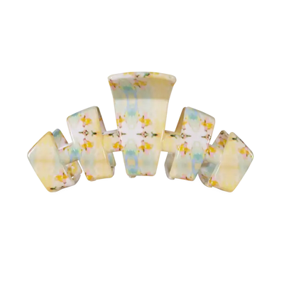 A retro-style multi-loop hair claw clip made of glossy, translucent resin with a pastel yellow, blue, and white marbled pattern and small yellow floral details, shown on a plain white background.
